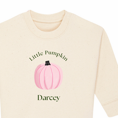 Beige long-sleeve shirt with pink pumpkin graphic and text on a white background
