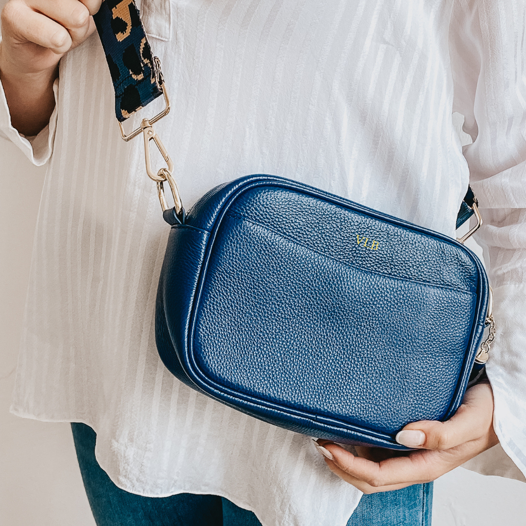 Blue leather bag being worn with white top and blue jeans