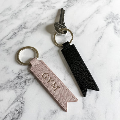 Black and pink keyrings on marble background