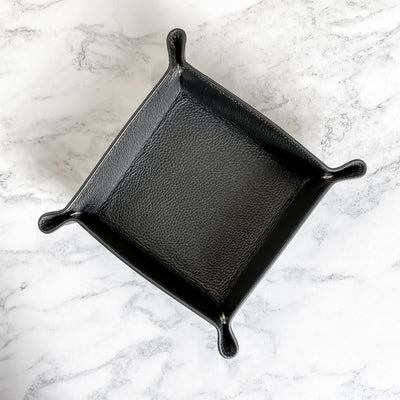 Black leather desk tray on a marble background