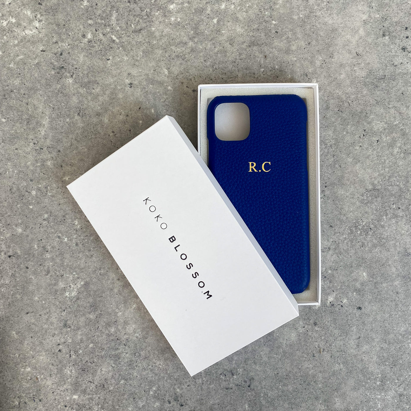 blue pebble leather phone case with embossed initials in a gift box