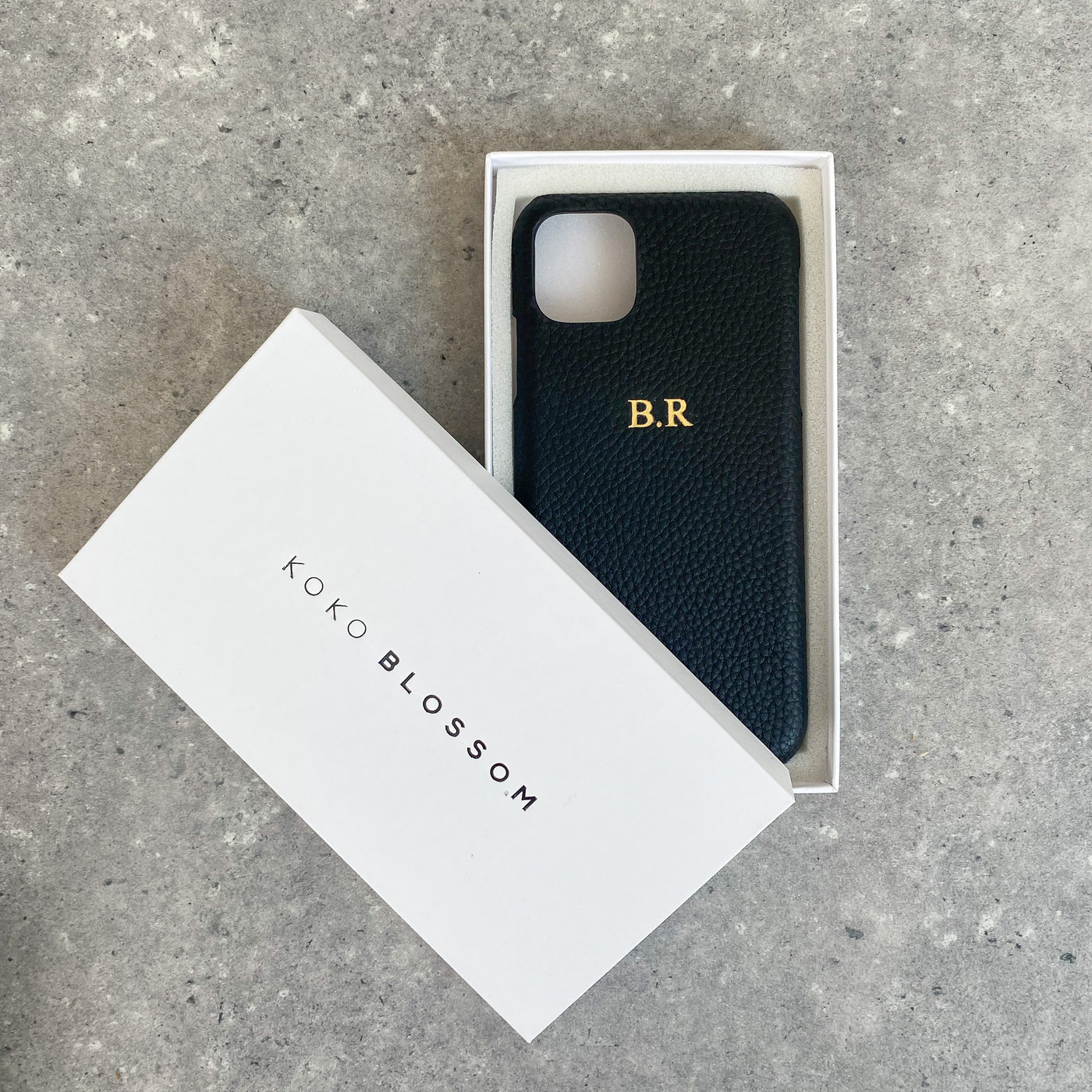 Black pebble leather phone case with embossed initials in a gift box
